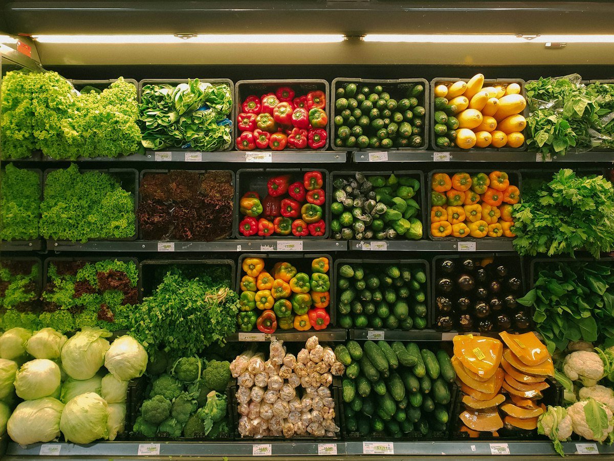 Well-stocked grocery store shelves with fresh vegetables