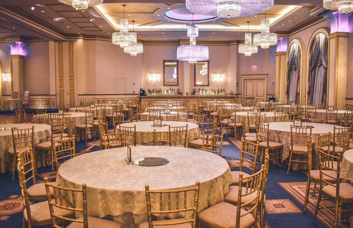 Elegant wedding hall set with round tables and chandeliers